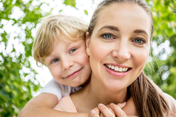 Mutter trägt ihren Sohn huckepack