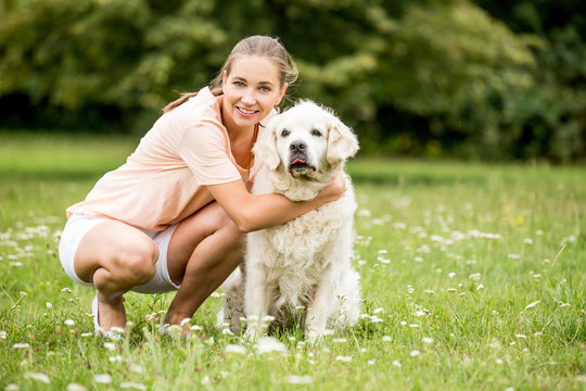 Glückliche Frau spielt mit Retriever