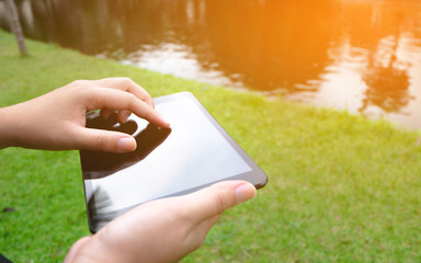 close up of Woman hands with tablet pc at a outdoors