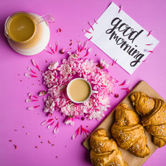 coffee and croissant on a pink background
