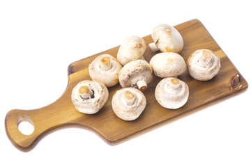Champignons on kitchen wooden cutting board.