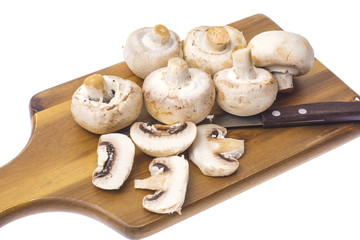 Champignons on kitchen wooden cutting board.