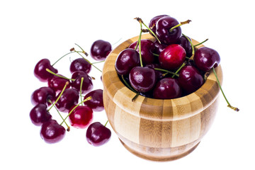 Red ripe juicy cherry in wooden bowl.