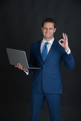 Man working on laptop and making ok gesture