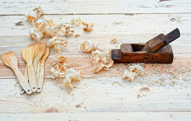 Plane on a wooden table in shavings. Wooden spatula.