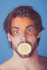 handsome surprised man with creative fashionable makeup hold lemon, vitamin