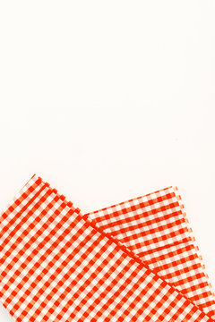 Orange cloth, a kitchen towel with a checkered pattern, on a white background isolated