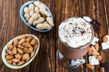 Chocolate banana smoothie with nuts  on a wooden table.