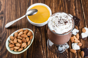 Chocolate banana smoothie with nuts  on a wooden table.