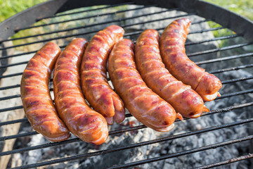 Grilling sausages on barbecue grill 