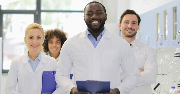 African American Scientist With Team Of Researchers In Modern Laboratory Happy Smiling Diverse Men And Women Slow Motion 60