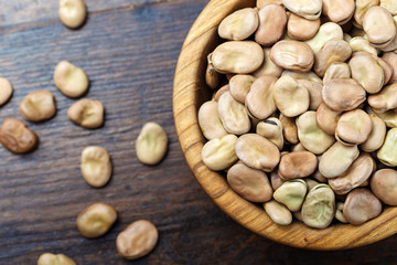 Dried broad beans in a wooden bowl