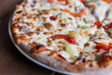 Tasty pizza close up. Pizza with onion, tomatoes, cheese, meat and pepper. Selective focus