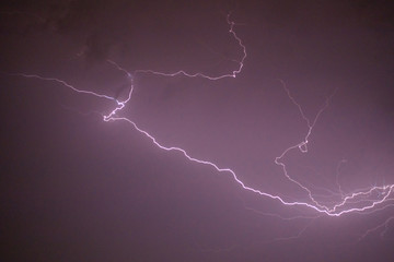 Photo of beautiful powerful lightning over big city, zipper and thunderstorm, abstract background, dark blue sky with bright electrical flash, thunder and thunderbolt, bad weather concept