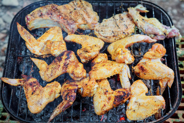 Grilling chicken wings on barbecue grill.