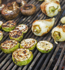 Vegetarian vegetarian barbecue, fried on a metal grill for grilling. The diet bbq. Zucchini, mushrooms and peppers close-up on a picnic outdoors. Street fast food. Tasty natural meals Selective focus