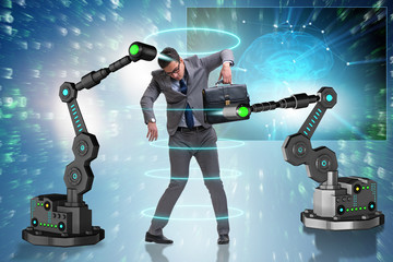 Businessman being manipulated by robotic arms