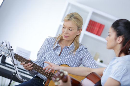 guitar teacher teaching a girl