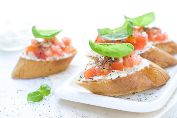 Bruschetta with cream cheese, tomatoes and basil