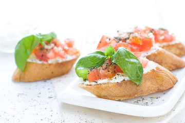 Bruschetta with cream cheese, tomatoes and basil