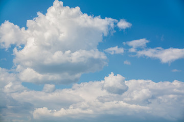 White curly clouds in a blue sky. Sky background
