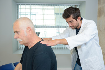 Fototapeta premium physiotherapist doing back massage to his patient in medical office