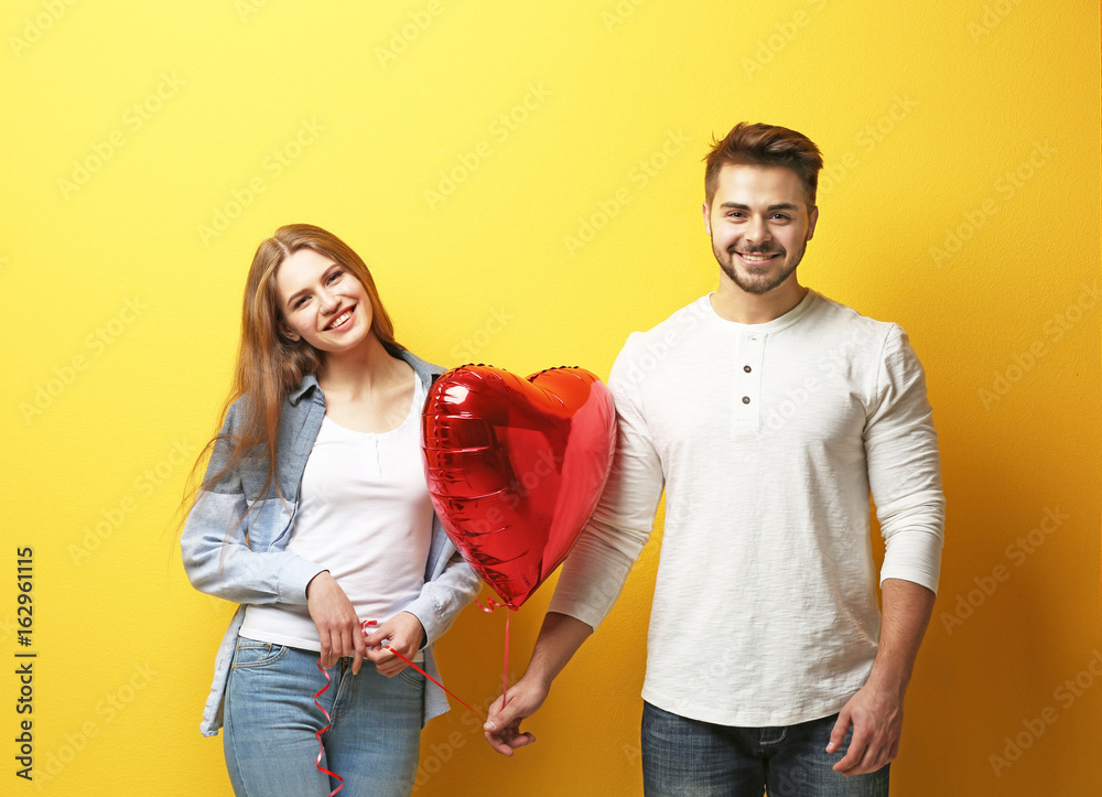 Canvas Prints cute young couple with balloon in shape of heart on color background