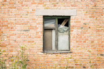 Abandoned house on donbass with boarded up old window. Brick wall background