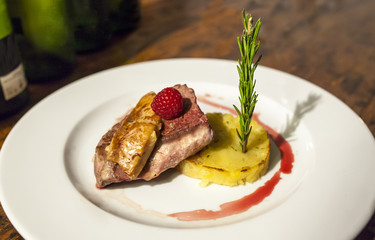 Grilled veal tenderloin with berries, potatoes au gratin, foie and rosemary branch