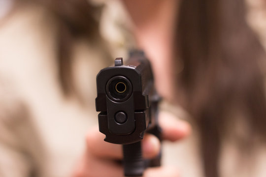 Mujer apuntando con una pistola