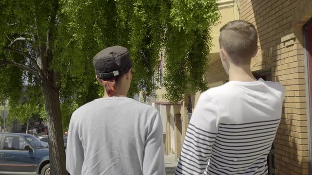 Happy Gay Couple Hold Hands And Enjoy Sunny Day In San Francisco, Man Touches Tree As They Pass