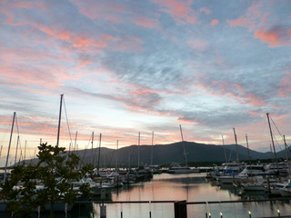 Colorful sunrise over mountains and sailboats