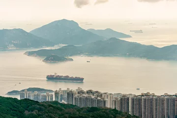 Fotobehang Lamma Island viewed from Victoria Peak on Hong Kong Island in Hong Kong. Container vessel transports cargo East Lamma Channel. Lots of distant sailing ships viewed far off on horizon. Scenic landscape © Wilding