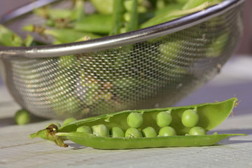 Freshly washed green peas on white wooden table. Nutrition, healthy eating concept