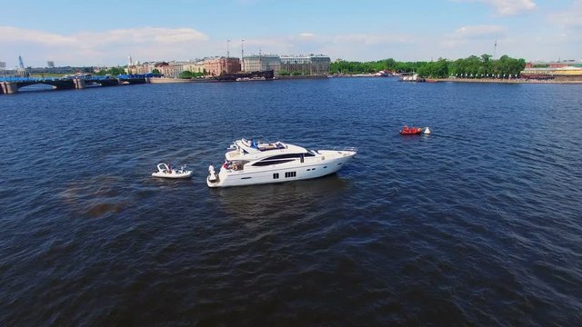 Small motorboat and luxury yacht in a city river