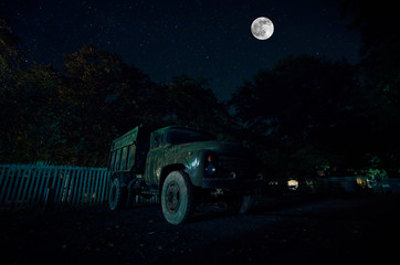 Mountain Road through the forest on a full moon night. Scenic night landscape of dark blue sky with moon. Azerbaijan. Long shutter photo