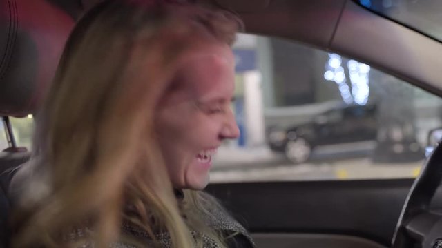 Happy Driver Sings And Dances During A Red Light, She Laughs And Looks Back At Passenger