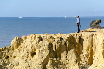 woman making photos on the cliff of the asperillo