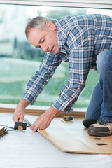 carpenter lining parquet boards to each other fitting a plank
