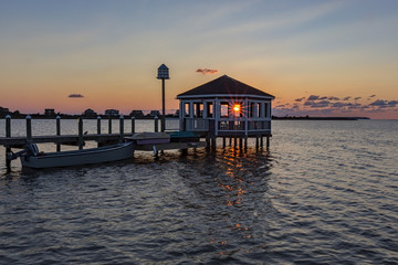 A sunset shing through a gazebo on the end of a dock in Abermarle Sound, Kill Devil Hills, North...