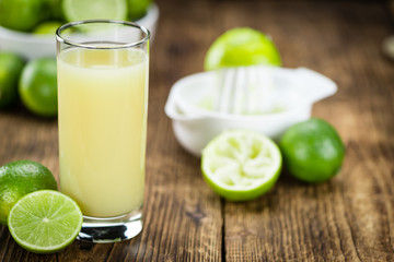 Portion of Fresh Lime Juice on wooden background (selective focus)