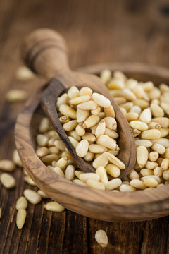 Portion of Pine Nuts on wooden background (selective focus)