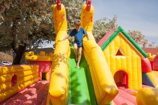 Young boy playing in an inflatable toy house in a park