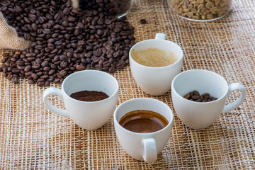 Cup of coffee on coffee beans background on a wooden table