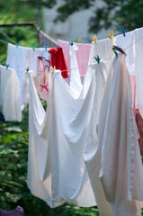 Linen out to dry on the rope.Washing hanging exposed to sunlight.Laundry hanging in a garden/Laundry line with clothes line in garden