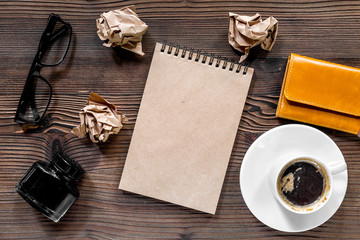 Writer workplace with vintage notebook, pen, glasses and coffee on wooden table background top view mockup