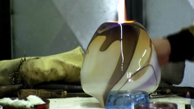 A beautiful vase is detached from punty then heated with blowtorch to soften base for logo impression