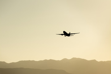 Airplane taking off over the mountains.