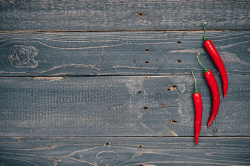 Red hot chili peppers on wooden background. Copy space. 