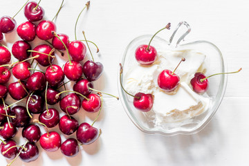 Ice cream decorated with fresh cherry on white table background top view